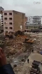 Excavator takes down six story building